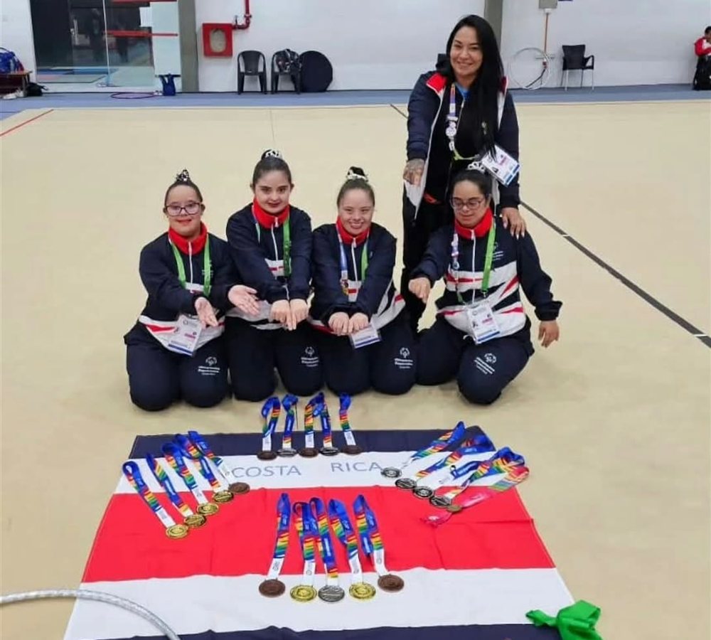 Gimnastas de Club Calderón con medallas y la bandera de Costa Rica